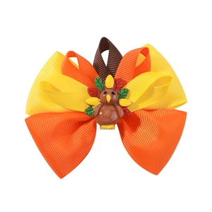 Close-up of Thanksgiving turkey bow hair clip featuring yellow orange and brown ribbons