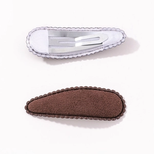 Detail of teardrop BB hair clips with dark brown plush surface and wavy scalloped edges