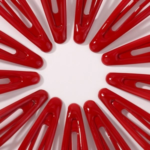 Vue détaillée de dessus des barrettes en métal rouge disposées en un motif circulaire