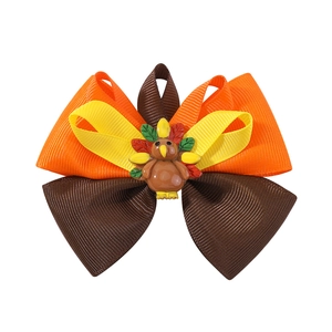 Detail of multi-layered Thanksgiving turkey hair bow with orange and yellow ribbons