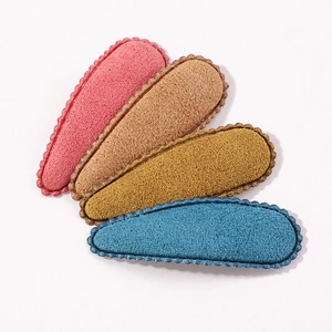 Detailed view of four colorful matte felt hair clips with scalloped edges for girls