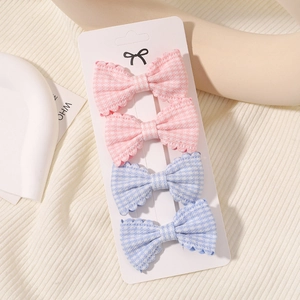 Detail of four-piece plaid bow hair clips in pink and blue on a display card