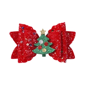 Gros plan d'un nœud de Noël rouge pailleté avec détail de sapin vert pour les cheveux