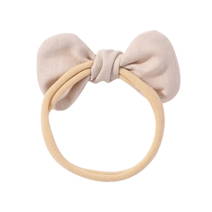 Detailed macro view of beige cotton linen bow headband with high-elastic seamless fabric band