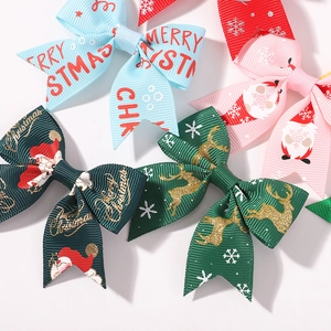Dettaglio di fiocchi natalizi per capelli con Babbo Natale, motivi di alce e testo Merry Christmas