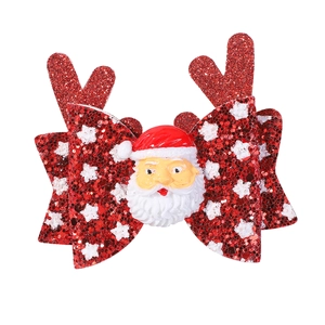 Détail de la pince à cheveux avec nœud rouge pailleté, bois de renne et père Noël
