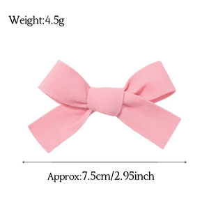 Détail de la barrette nœud en velours rose montrant la taille 7,5cm et le poids 4,5g