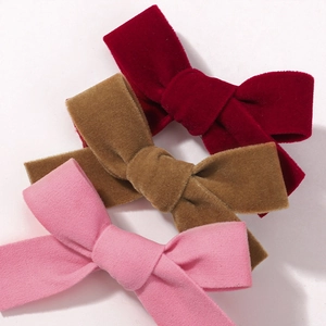 Barrettes à nœud en velours en bordeaux, marron et rose sur fond blanc