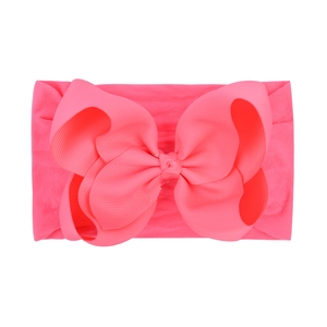 Detailed view of flexible pink nylon headband with large grosgrain ribbon bow
