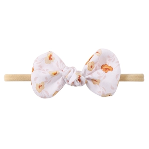 Detailaufnahme Baby-Haarband aus Nylon mit orangefarbener Blumenschleife auf Weiß