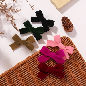 Vue à plat de barrettes à nœuds en velours de six couleurs avec décor d'automne naturel