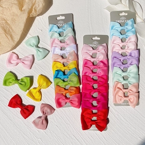 Detail showing assorted colorful handmade ribbon bow hair clips on a display card for girls