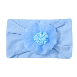 Dettaglio di una fascia morbida azzurra per neonati con un grande fiore in tessuto a mano