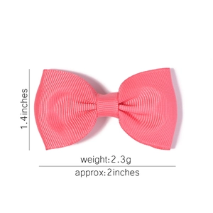 Detailed view of pink grosgrain bow accessory with size marks 2 inches and 1.4 inches