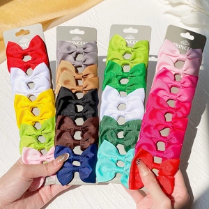 Detailed view of colorful grosgrain ribbon bow clips on a grey display card