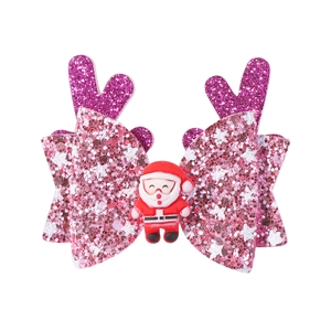 Détail d'une pince à cheveux de Noël à paillettes roses avec bois de renne et Père Noël