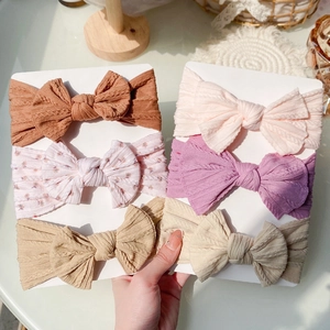 Vue détaillée de bandeaux bébé élastiques en maille texturée avec nœuds décoratifs 3D