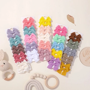 Dettaglio del set di fermagli per capelli a fiocco in tessuto waffle colorato per bambine
