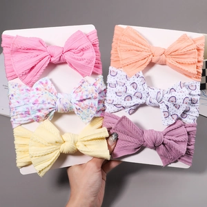 Detailed view of 6-piece soft nylon baby headbands with varied bow patterns and colors