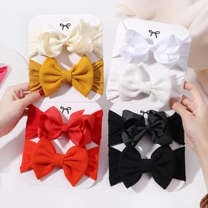 Close-up of baby headbands with textured waffle and satin bows in diverse colors
