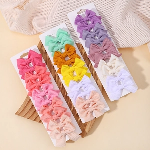 Dettaglio del set di fermagli per capelli con fiocchi in tessuto a nido d'ape colorati