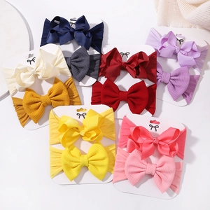 Close-up of baby bow headbands in various colors and textured fabrics on display cards