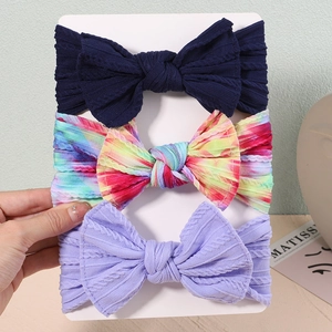 Detailed macro view of a 3-pack set of nylon baby headbands with textured knit bows