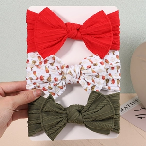 Detail view of 3-pack baby nylon headbands with large bows on a white display card