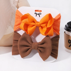 Detail of orange ribbed and brown waffle bow headbands displayed on white card