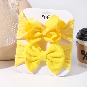 Detail view of yellow baby bow headbands showing ribbed and waffle fabric textures
