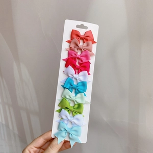 Close-up of 10 multicolor grosgrain ribbon bow hair clips on display card for little girls