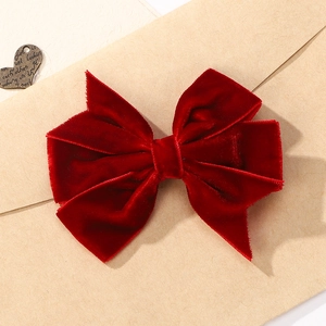Détail d'une pince à cheveux avec nœud en velours fait main en tissu rouge luxe