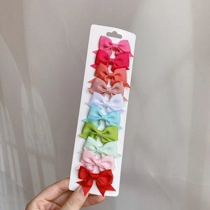 Set of 10 colorful grosgrain ribbon swallowtail hair bows for girls on a white card