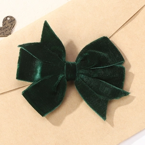 Détail d'un nœud papillon en velours vert forêt sur fond de papier vintage