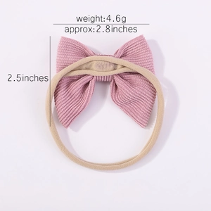 Détail d'un nœud en velours côtelé rose sur bandeau en nylon beige pour bébés avec tailles
