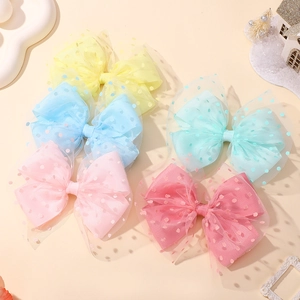 Detailed view of layered mesh and polka dot hair clips in vibrant candy colors