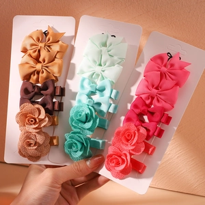 Set of colorful handmade fabric bow and flower hair clips for girls on white cards