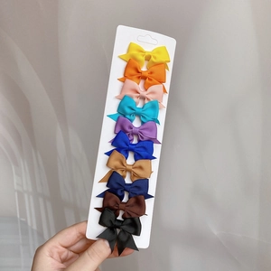 Set of 10 colorful grosgrain ribbon swallowtail hair bows for girls on a display card