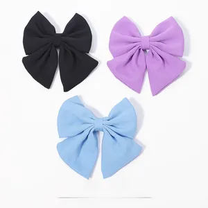 Détail macro de la texture satinée et couture des barrettes nœuds pour filles