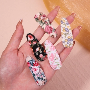 Vue détaillée d'un lot de 5 barrettes à cheveux en tissu floral tenues à la main