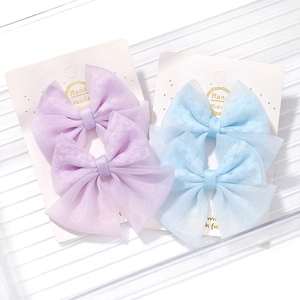 Détail de barrettes à cheveux en tulle faites main en violet et bleu sur cartes