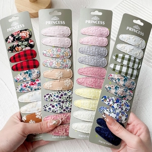 Détails des motifs floraux, à carreaux et brodés sur les barrettes à cheveux BB