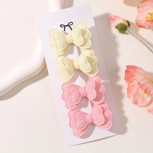 Detail view of 4-piece butterfly hair clips on white cardstock with a soft floral background