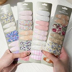 Détail de diverses barrettes BB en tissu brodé à la main avec des motifs floraux