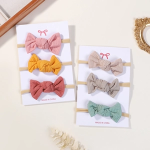 Detailed close-up of 6-pack baby bow headbands featuring soft ribbed knit fabric texture