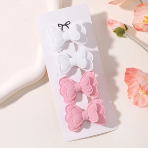 Detail of four fabric butterfly hair clips in pink and white on a branded card