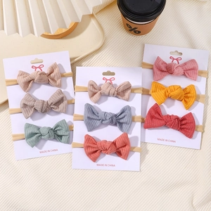 Detail view of 9-pack nylon bow headbands set with soft ribbed fabric on cardboard