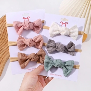 Set of 6 ribbed fabric baby bow headbands in various soft colors on display card