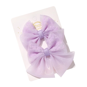 Paire de pinces à cheveux nœud en maille violet clair avec broderie sur carte d'exposition