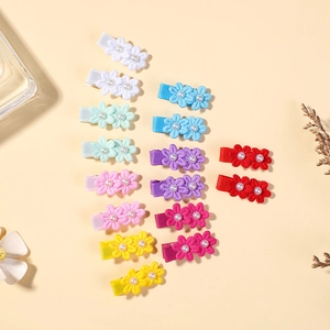 Dettaglio di fermagli per capelli con fiori in tessuto fatti a mano e perle su beige